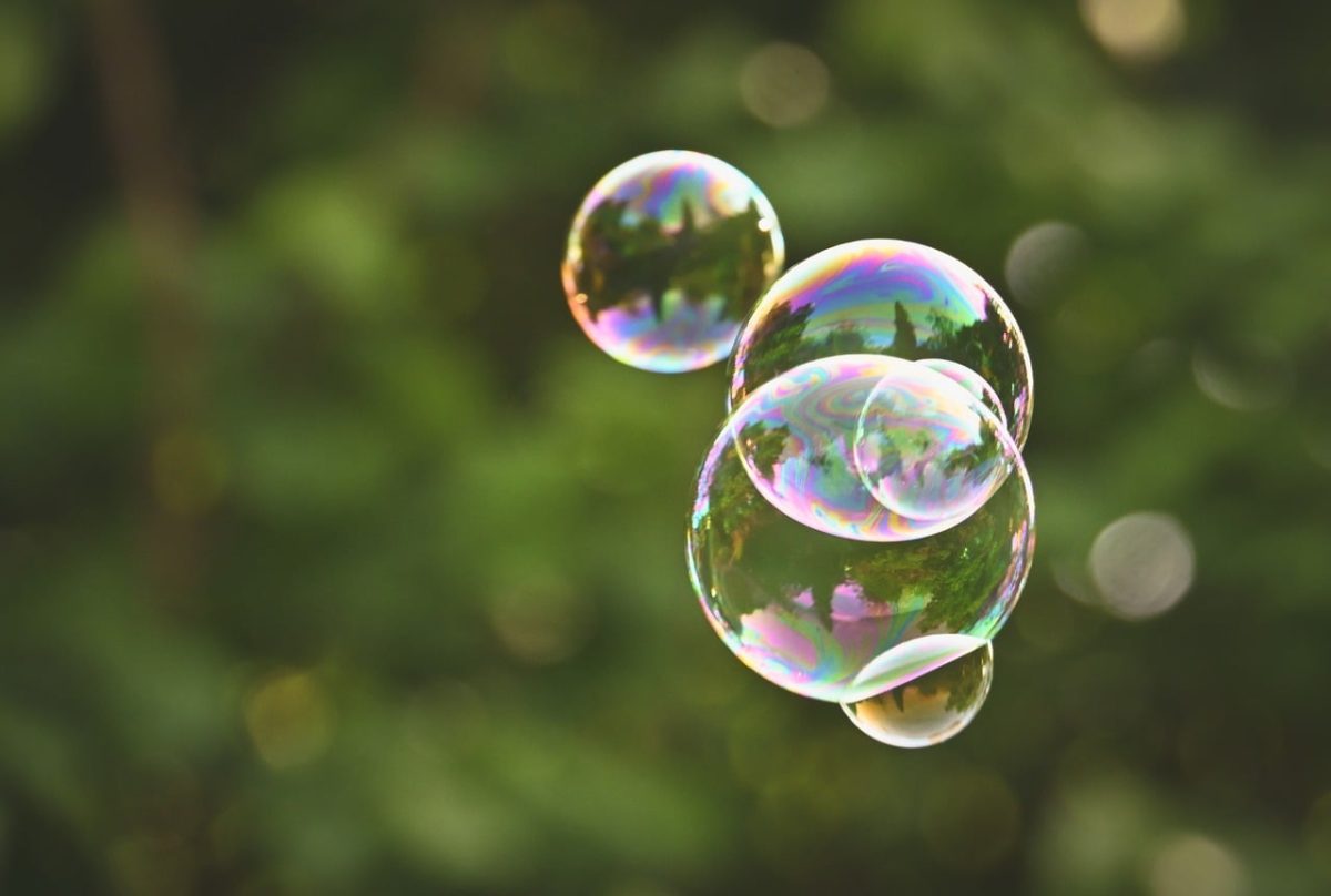soap bubbles, summer day, green background, outdoor activities, colorful, magical atmosphere, crystal balls, blur effect, children's entertainment, light reflections, natural light, transparency, abundance, playful mood, photographic art, macro photography, bubble magic, children's games