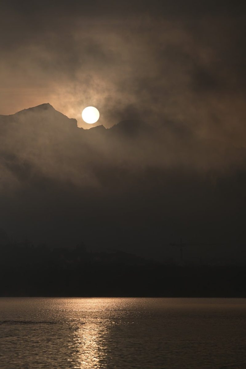 mountains, sunset, water surface, reflection, dark clouds, mountain silhouette, lake, landscape, calm, natural scenery, twilight, calm water, light effect, breathtaking, nature, evening, peace, relaxation