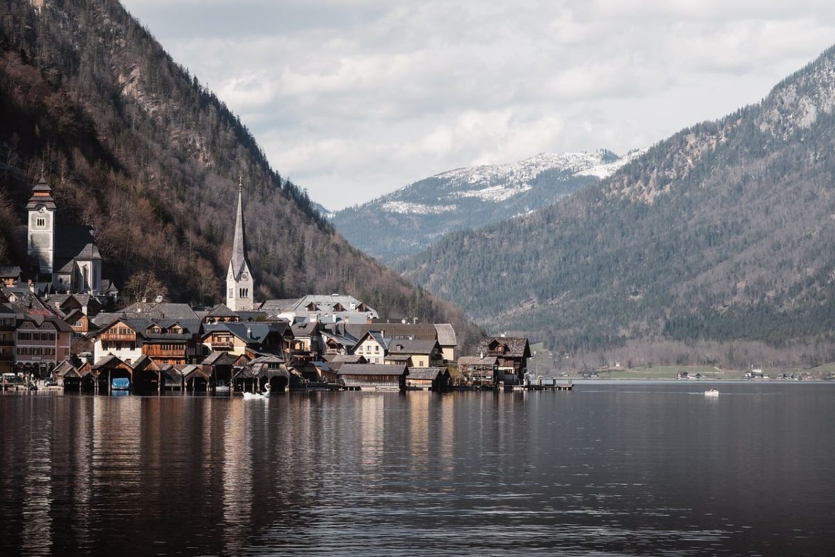 hallstatt, village, lake, church spire, nature, reflection, spring, scenery, alps, tranquil, houses, tourist destination, water reflection, cloudy sky, austrian alps, phone wallpaper, 4k wallpaper, natural beauty, recreation, hd wallpaper, mountain landscape