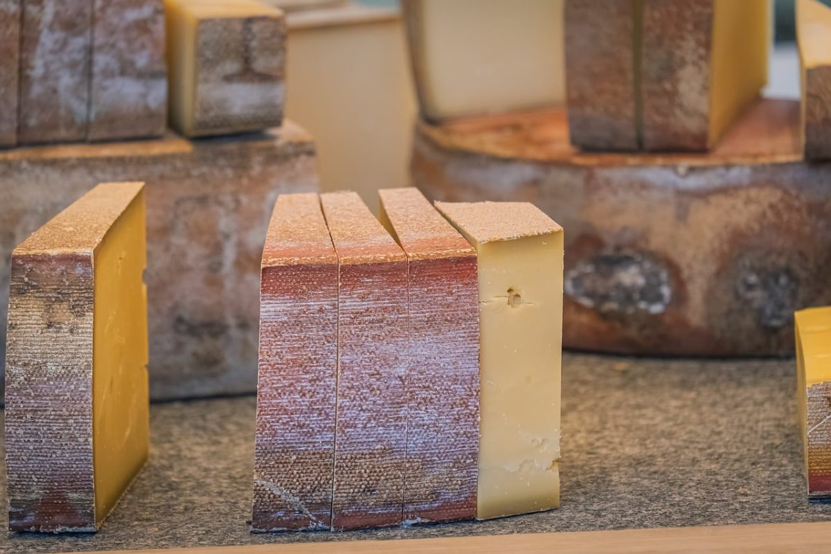 cheese, slice, hard cheese, dairy products, artisanal, traditional, wheel, rustic, cheesemaking, gourmet, flavor, yellow, texture, tasting, sliced cheese, table, close-up, aging, aroma, piece, structure