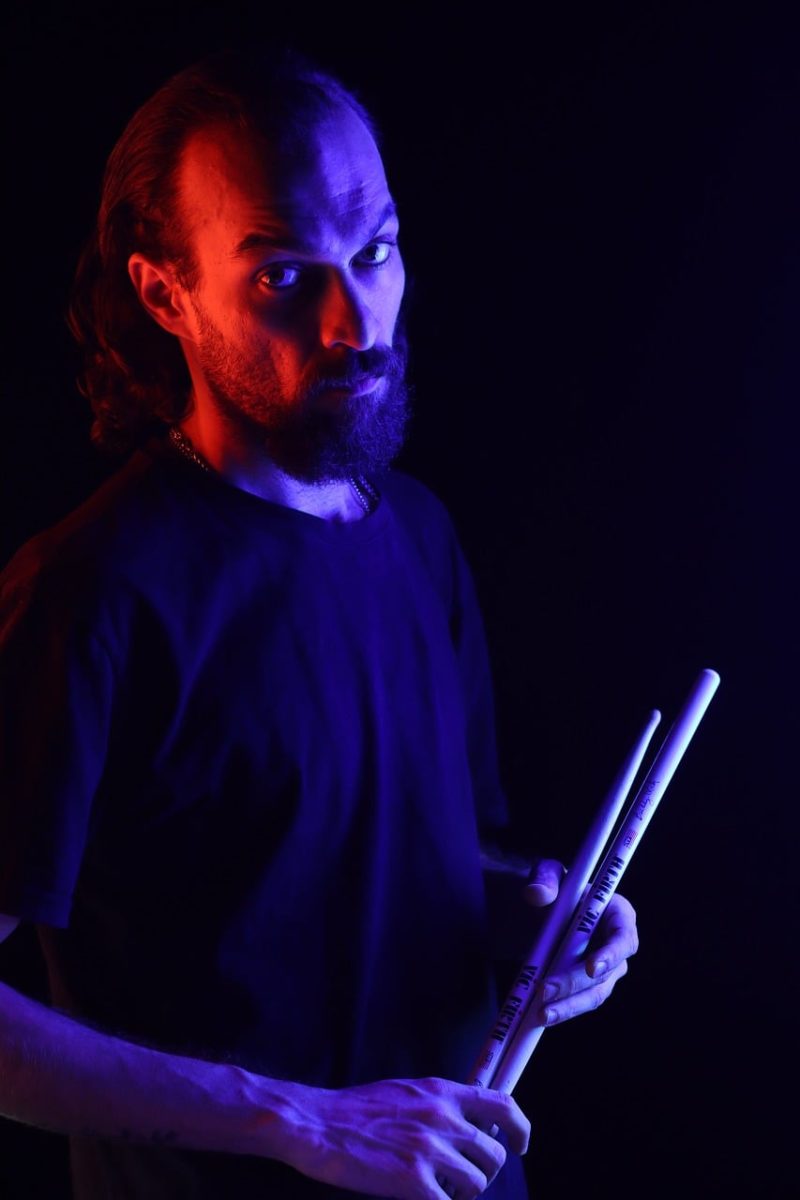 portrait, musician, drummer, drumsticks, blue light, purple light, dark background, dramatic lighting, creative photography, artist, creative portrait, studio portrait, persian, male, moody, colorful lighting, musician portrait, cinematic, studio