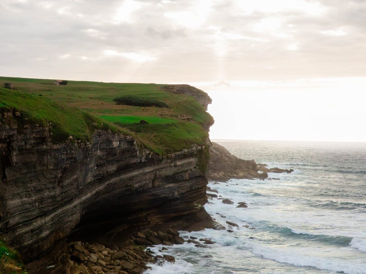 sea cliffs, ocean waves, coastal landscape, green fields, nature, cloudy sky, dramatic landscape, rocky coast, natural scenery, ocean waters, coastal drama, sunrise, natural beauty, natural landscape, cliffs and waves, coastal path, moody view, horizontal frame, moody atmosphere, natural retreat