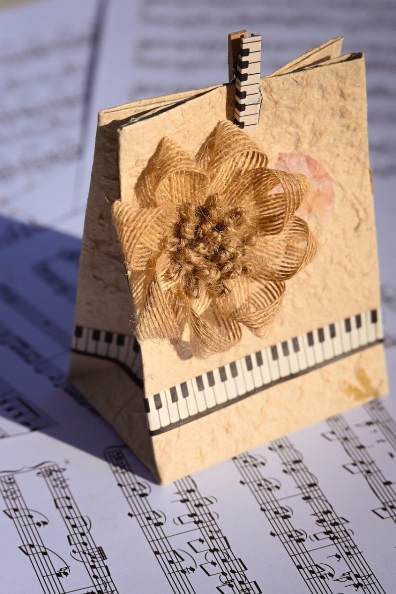 handmade card, gift bag, paper craft, floral decoration, jute flower, rustic design, piano keys, music notes, sheet music, artistic background, vintage style, decorative paper, creative craft, eco friendly design, musical theme, handmade gift, textured paper, floral ornament, arts and crafts, creative background, paper art, diy decoration, craft project, music and art, rustic charm
