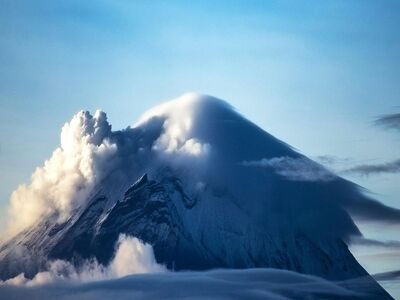 mountain, nature, landscape, volcano, smoke, clouds, summit, blue sky, daytime, majestic, winter, geology, natural force, dramatic, scenery, awe-inspiring, pristine, lonely, rawness