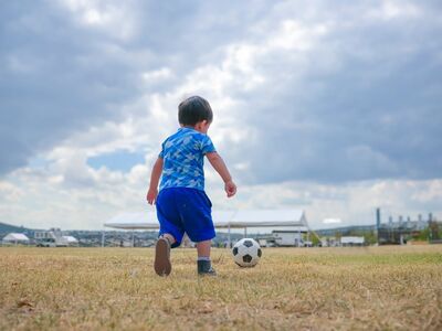 football, child, kick, meadow, playing, leisure, running, boy, playground, artificial grass, cloudless, blue clothing, child's play, outdoor activities, shoe, nature, clouds, joy, fun, childhood, natural environment