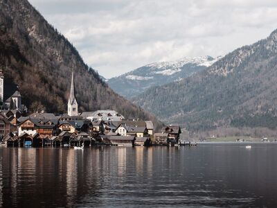 hallstatt, village, lake, church spire, nature, reflection, spring, scenery, alps, tranquil, houses, tourist destination, water reflection, cloudy sky, austrian alps, phone wallpaper, 4k wallpaper, natural beauty, recreation, hd wallpaper, mountain landscape