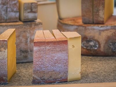 cheese, slice, hard cheese, dairy products, artisanal, traditional, wheel, rustic, cheesemaking, gourmet, flavor, yellow, texture, tasting, sliced cheese, table, close-up, aging, aroma, piece, structure