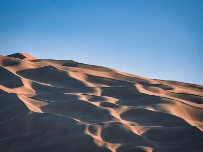 desert, sand dunes, light blue sky, desert landscape, light reflections, shadows, sand waves, natural landscape, no people, silence, desolate area, loneliness, nature, aridity, horizon, lonely landscape, summer day, peaceful atmosphere, golden tones, warmth