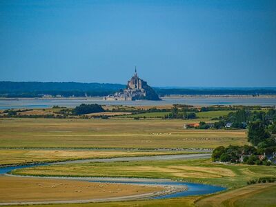 mont saint-michel, normandy, historic architecture, abbey, island community, medieval fortress, unesco world heritage, sheep, meadow, natural landscape, tower, abbey on a hill, landscape with streams, tourist attraction, church architecture, famous landmark, mediterranean climate, vineyard, culture
