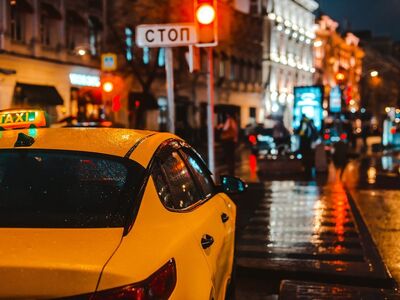 taxi, city at night, traffic signal, yellow, lighting, rainy, street, nighttime, vehicle, rainy evening, stop sign, square, red light, stop traffic, reflective surface, traffic jam, sidewalk, raindrops, urban traffic, evening city