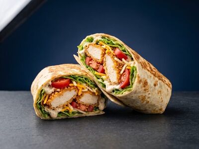 wrap, chicken wrap, crispy chicken, lettuce, tomatoes, tortilla, cheddar cheese, sauce, slate table, blue background, studio shot, delicious, sandwich, fast food, gourmet, flatbread, mayo, fried chicken, grilled wrap, halved
