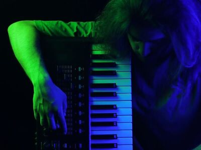 man, musician, keyboard, colorful lighting, blue light, purple light, dark background, dramatic lighting, studio, creative lighting, photography, art, moody, musician portrait, male portrait, blue and purple, musical instrument, emotive, pose