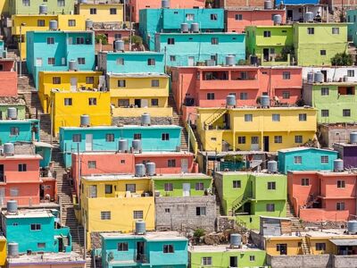 colorful houses, urban architecture, vibrant colors, eclectic style, latin america, sunny day, neighborhood, hilly terrain, wide angle, entrance level, concrete stairs, landmark, iconic site, tourist destination, camera photography, urban environment, elevation, enclosed space, roof patterns