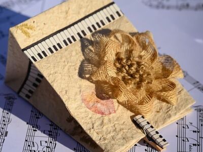 handmade card, gift bag, rustic craft, paper art, floral decoration, jute flower, piano keys, music notes, sheet music, vintage style, decorative paper, eco friendly design, artistic background, craft project, handmade design, music inspired, creative craft, textured paper, diy decoration, floral ornament, arts and crafts, creative background, rustic charm, music and art, handmade gift